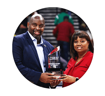 Circle shaped image of a man and woman holding a MEAC crystal style award